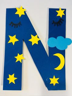 the letter n is made out of paper and has stars, clouds, and moon on it