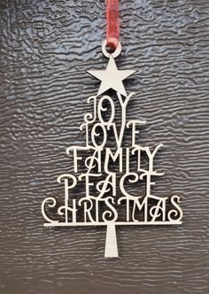 a metal christmas tree ornament hanging on a wall