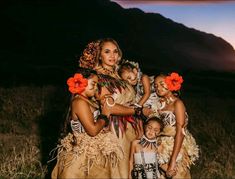 a group of women and children dressed up in native clothing standing next to each other