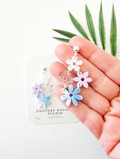 These pretty Pastel Summer Floral Chandelier Earrings are so aesthetic with their mixed florals. They are made using a combination of 4 different acrylic flowers in white glitter, matte lilac, blue white and lilac marble and clear glitter. The total length of these earrings measure 2 inches tall and 1.25 inches wide. These earrings are set using your choice of Stainless Steel Silver or Gold Ball Posts OR lead free and nickel free ear wires (suitable for even sensitive ears) in a Gold or Silver finish. Each pair of earrings come shipped with backings, attached to an earring card and sealed in their own clear packaging. All earrings purchased from my shop ship in a box so they arrive safely to you. Earrings Preppy, Lilac Marble, Preppy Vacation, Clear Packaging, Lilac Blue, Flower Chandelier, Floral Chandelier, Glitter Flowers, Earring Card