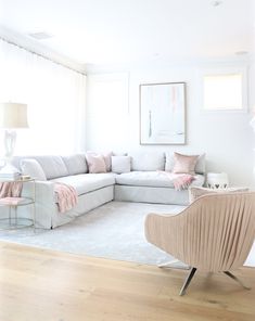 a living room filled with furniture and a white rug on top of a hard wood floor