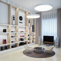 a living room filled with furniture and a flat screen tv on top of a wooden shelf