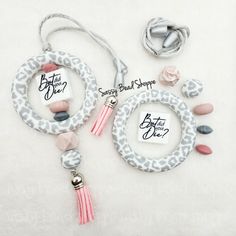 two necklaces with name tags on them sitting next to each other in front of a white background