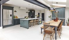 a large kitchen with an island table surrounded by chairs