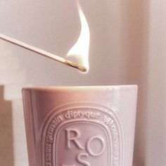 a lit matchstick sticking out of a cup with the word ros on it