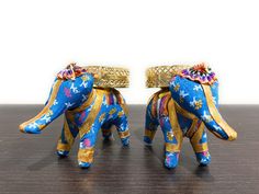 two small blue elephants with gold decorations on their backs, sitting next to each other