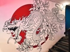 a large dragon painted on the side of a wall next to some stairs in a building