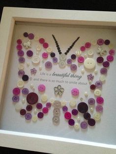 a shadow frame with buttons in it that says beautiful living and there is so much to smile about