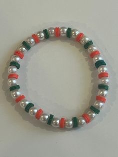 This is a beaded bracelet with clay beads and pearl beads in between them. This bracelet comes in three colors, red, green, and multicolored. Clay Bracelet Christmas, Clay Beads Bracelet Ideas Christmas, Clay Bracelet Ideas Christmas, Cute Clay Beads Ideas, Christmas Bracelets Clay Beads, Pearl Clay Bead Bracelet Ideas, Christmas Braclets Ideas, Christmas Bracelets Ideas, Christmas Clay Bead Bracelet Ideas