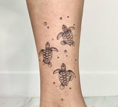 a woman's foot with three turtles and bubbles on the bottom of her leg