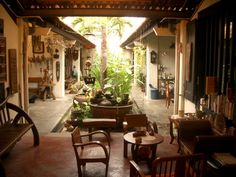 an outdoor living area with chairs, tables and potted plants