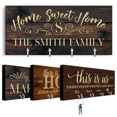 three wooden signs hanging from hooks on the wall, each with their own family name