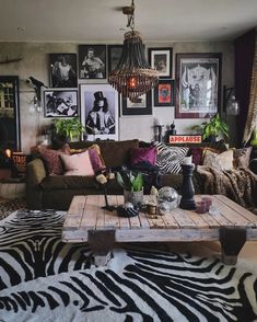 a living room with zebra print rugs and pictures on the wall behind the couch