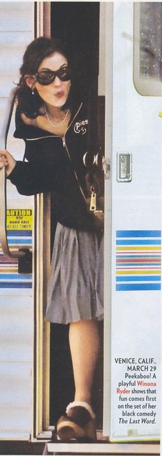 a woman is standing in the doorway of a train with her hand on her hip