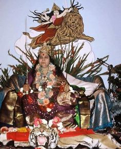 a woman sitting on top of a golden throne next to a tiger and other animals