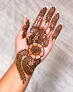 a woman's hand with henna tattoos on it