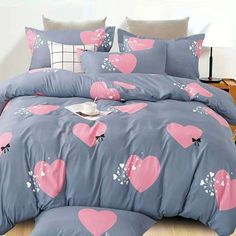 a bed with pink and grey hearts on it