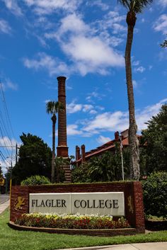 the sign for flagr college is shown in front of palm trees and landscaping on a sunny day