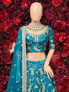 The Amberly Lehenga Set in teal features intricate silver embroidery, a voluminous skirt, and a matching dupatta, making it a perfect choice for weddings or grand events. Key Features: Color: Rich teal with silver embroidery. Design: Embroidered blouse and skirt with detailed floral and geometric patterns. Dupatta: Matching sheer dupatta with embroidered border. Style: Traditional lehenga with modern detailing, creating a regal appearance. Occasion: Perfect for weddings, receptions, or festive o Blue Bride Dress, Buy Lehenga Online, Indian Bridal Couture, Traditional Lehenga, Elegant Veils, Reception Gowns, Blue Bride, Mehendi Outfits, Weddings Receptions