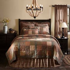 a bedroom with a chandelier and bedding in brown, beige and tan colors