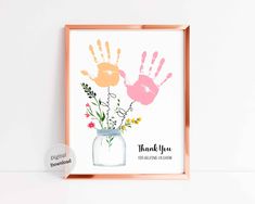 a pink and orange hand print with flowers in a mason jar