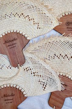 three wooden paddles with lace on them sitting on top of a cloth covered table