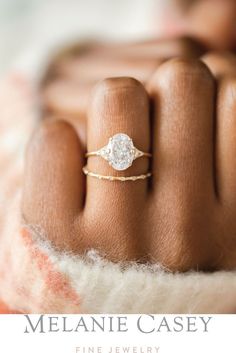 a woman's hand with a diamond ring on it and the words melanie casey fine jewelry