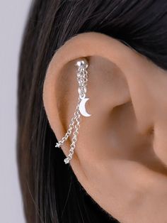 a close up of a person's ear with a chain attached to the back of it