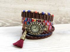 Bohemian watch bracelet Colorful wristwatch Wrap Boho watch Multicolor Boho Watch for Woman gift Boho Rainbow Watch Brown Red Watch  Bohemian watch bracelet with a colorful textile band and quartz mechanism. This wrap boho watch can be worn as a spectacular boho jewelry. A perfect gift for a friend or for the woman you love. It has two separate bracelets to the watch: - the first bracelet is made from a brown suede band, brown cotton cord, and blue, red, and gold glass beads - the second one is made from brown and dark blue suede cord You can order wristwatch only or wristwatch and one or the two bracelets as follow: - All Set - you will receive the wristwatch and the both bracelets - Wristwatch only - you will receive the wristwatch only - Watch+Beads Bracelet - you will receive wristwatc Multicolor Analog Watches As Gift, Multicolor Analog Watches For Gift, Gift Multicolor Analog Watches, Vintage Multicolor Quartz Watch, Multicolor Bracelet Strap Watch As Gift, Multicolor Watches With Bracelet Strap As Gift, Adjustable Bohemian Style Watches As Gift, Bohemian Style Adjustable Watches As Gift, Handmade Multicolor Watch Accessories For Gift