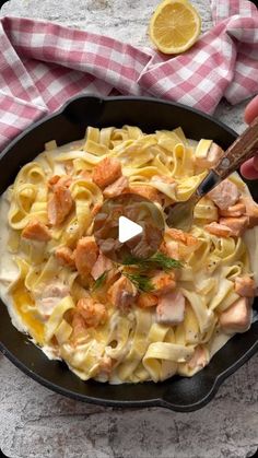 a pan filled with pasta and meats on top of a table next to a knife