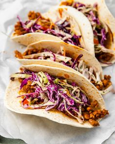 three tacos with shredded cabbage and meat