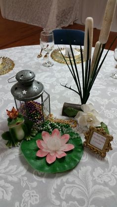 a table topped with lots of different items on top of a white table cloth covered table