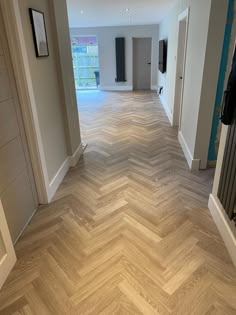 an empty hallway with wood flooring in the middle and blue accents on the walls