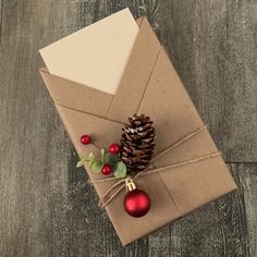 an envelope wrapped in brown paper and tied with twine, decorated with christmas ornaments