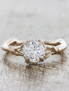 a gold ring with a white diamond in the center