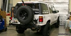 an off road vehicle is parked in a garage next to some tools and other items