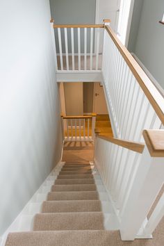 the stairs lead up to the second floor in this house with white painted walls and wood handrails