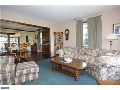 a living room filled with furniture next to a dining room table and chairs in front of a window