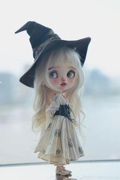 a doll with blonde hair wearing a witches hat