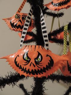 an ornament hanging from a christmas tree decorated with orange and black halloween decorations