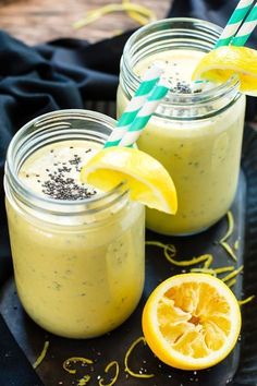 two mason jars filled with lemonade and garnished with straws on a black plate