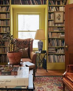 a living room filled with lots of books and furniture