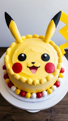 a pokemon cake with pikachu decorations on it's face and ears, sitting on top of a wooden table