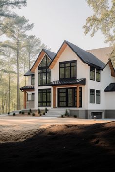 a large white house with lots of windows on the front and side of it, surrounded by trees