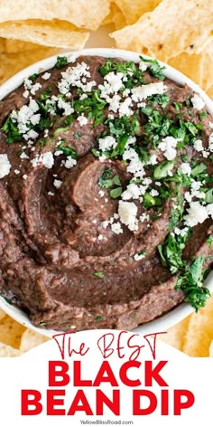 the best black bean dip recipe in a bowl surrounded by tortilla chips and cilantro