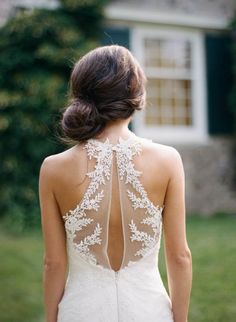 the back of a woman's wedding dress with an intricate lace design on it