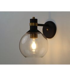 a light that is on the wall next to a white wall with a glass ball