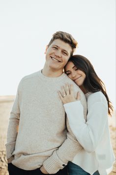 a man and woman hugging on the beach