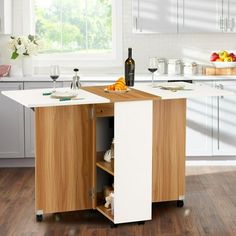 a kitchen island with wine bottles on it in the middle of a hardwood floored room