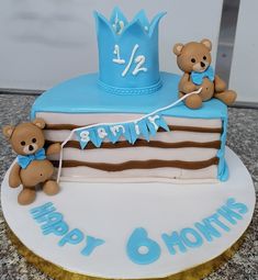 a birthday cake with two teddy bears and a blue crown on top that says happy 8 months